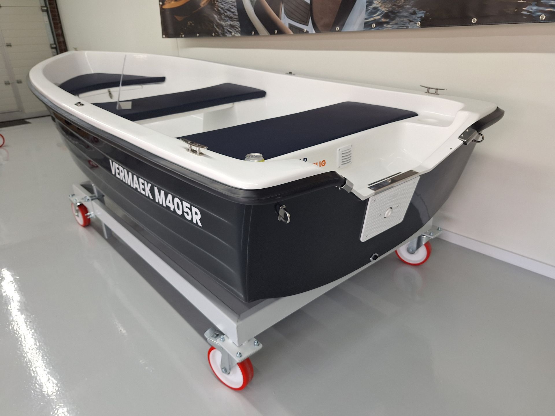 Een kleine boot staat op wielen in een garage