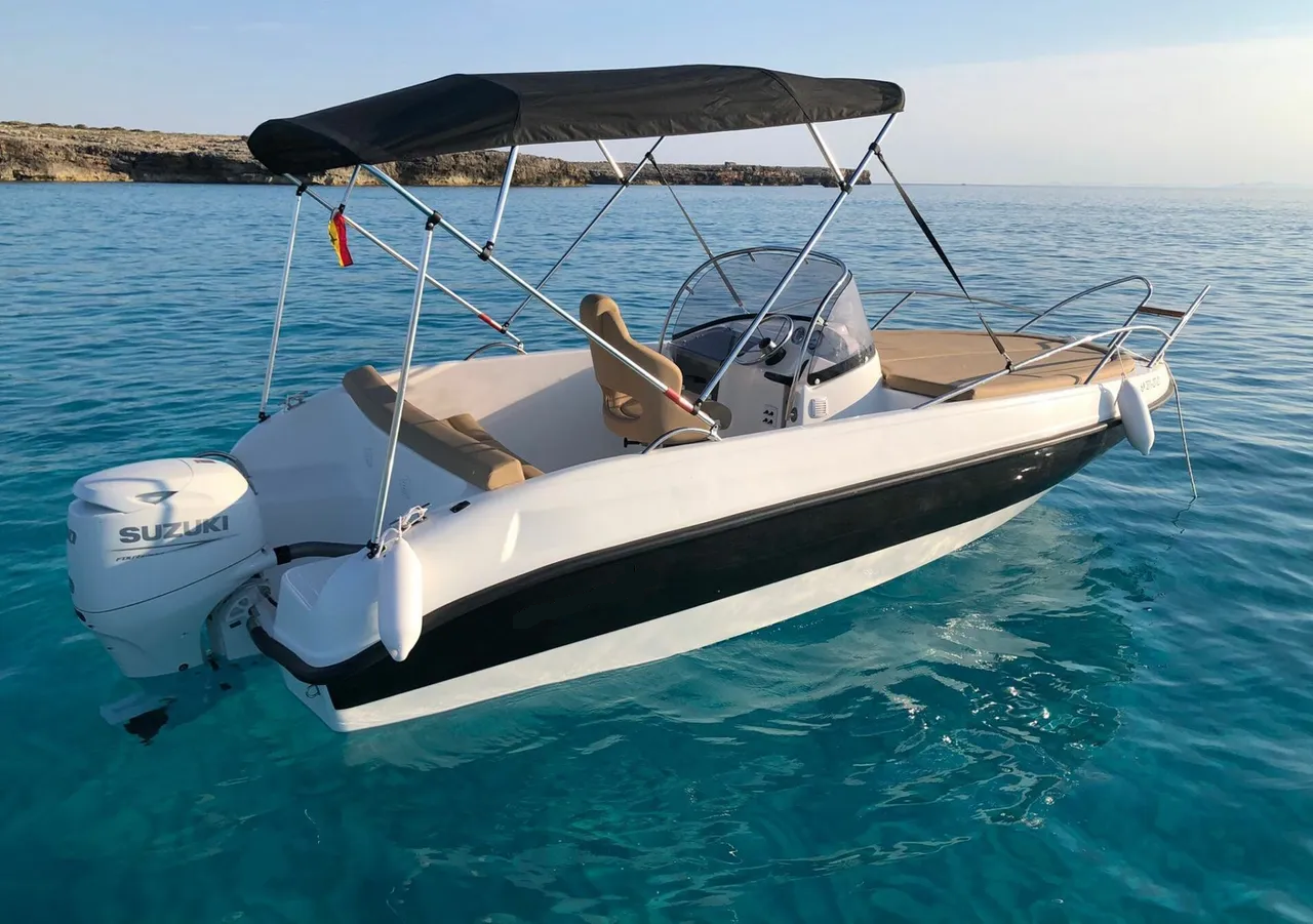 Een boot met een kap drijft op een watermassa.