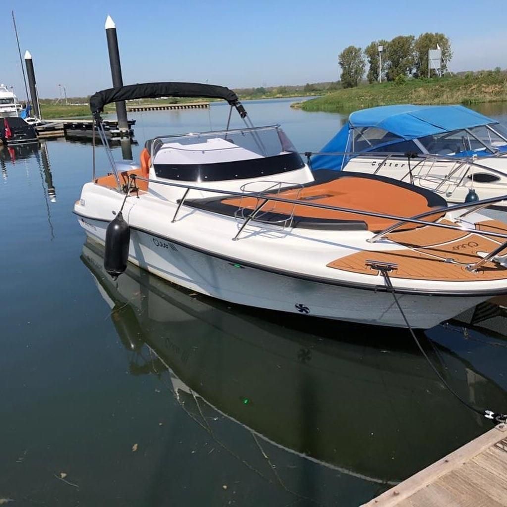 Een boot ligt in een jachthaven aangemeerd naast een andere boot.