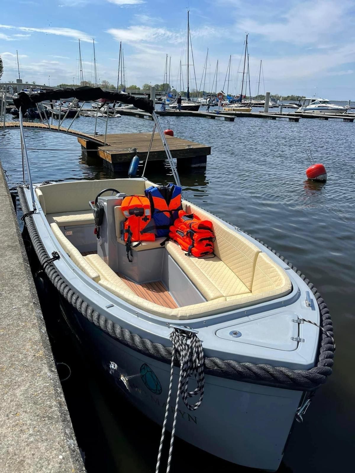 Een kleine boot ligt aangemeerd aan een steiger in het water.