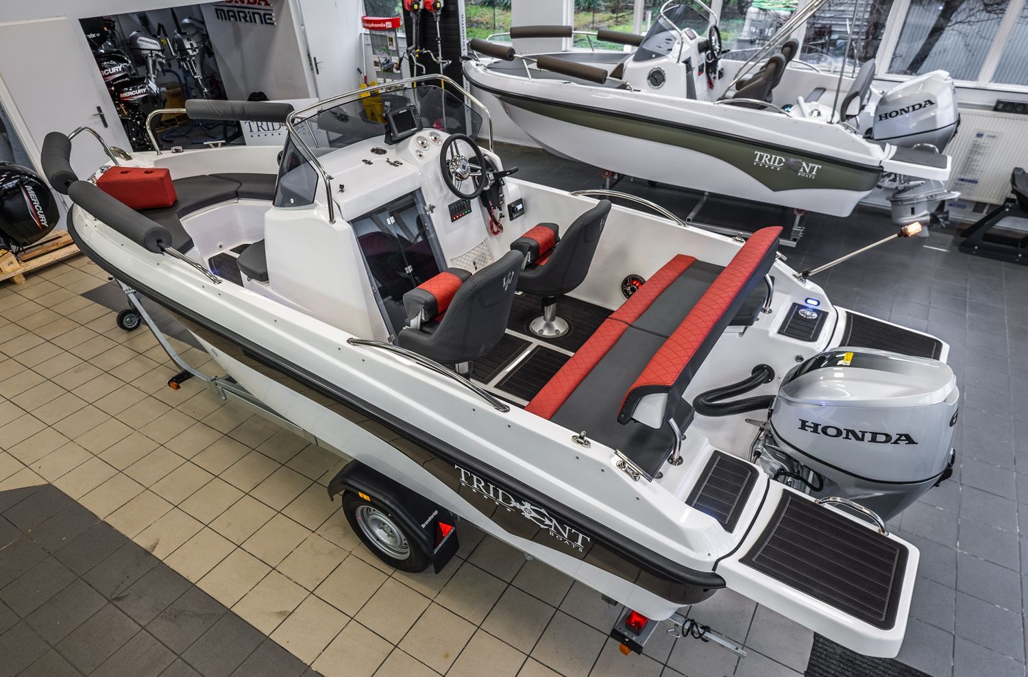 Een wit-rode boot staat op een trailer in een showroom.
