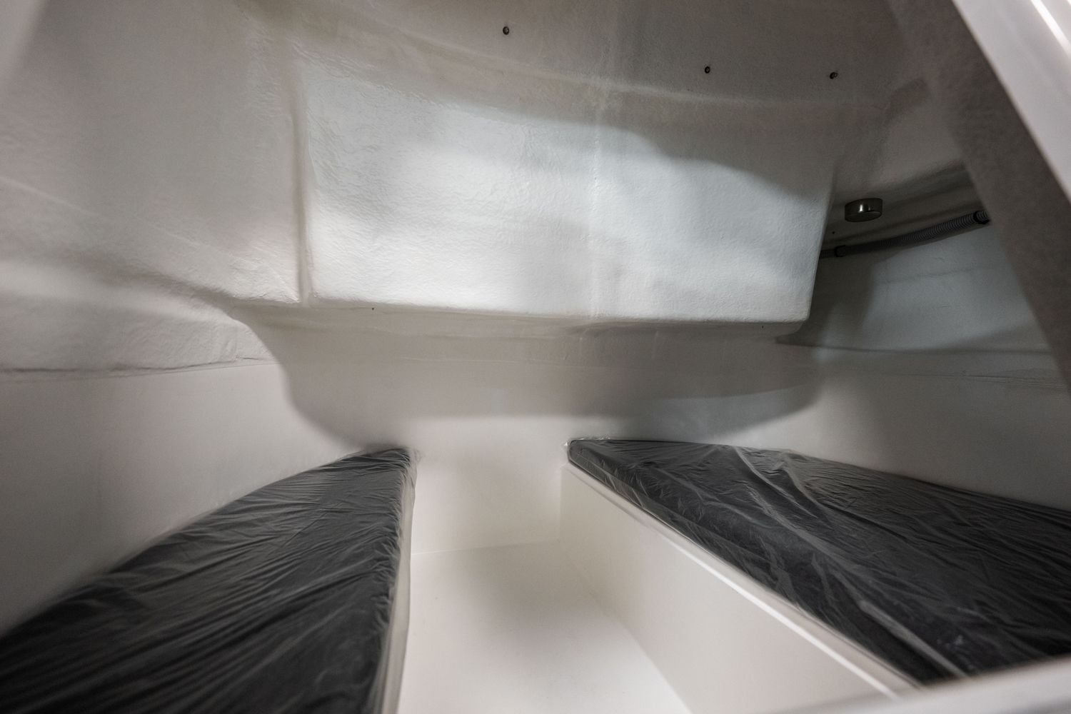 De binnenkant van een boot met een bed en een trap.