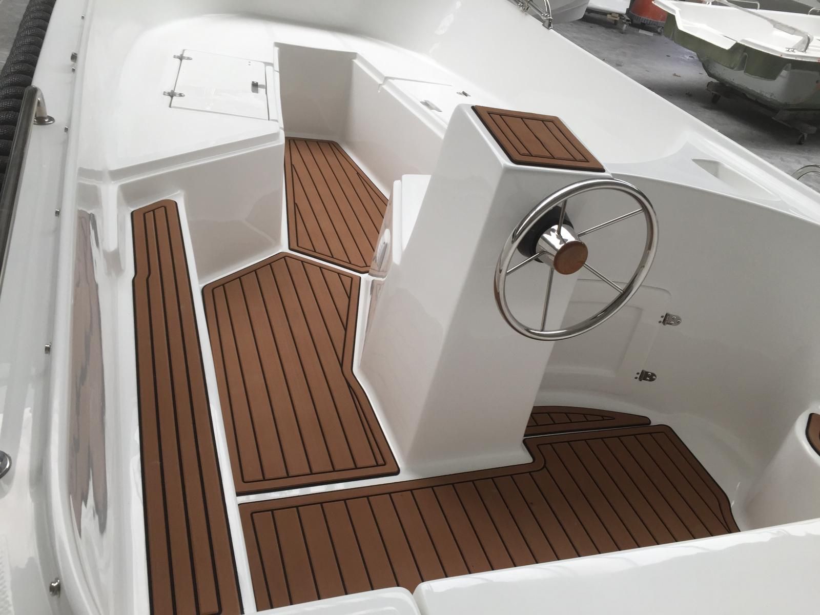 Een witte boot met houten vloeren en een stuurwiel