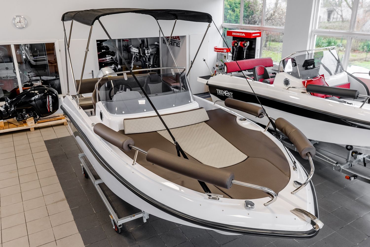 Een wit-bruine boot met een kap staat in een showroom.