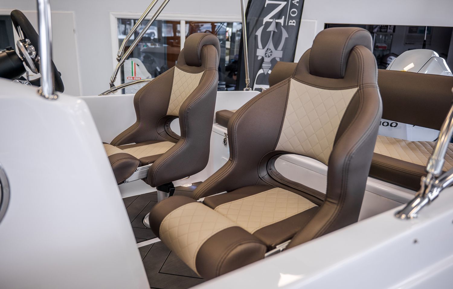 Een boot met twee bruine en beige stoelen in een showroom.