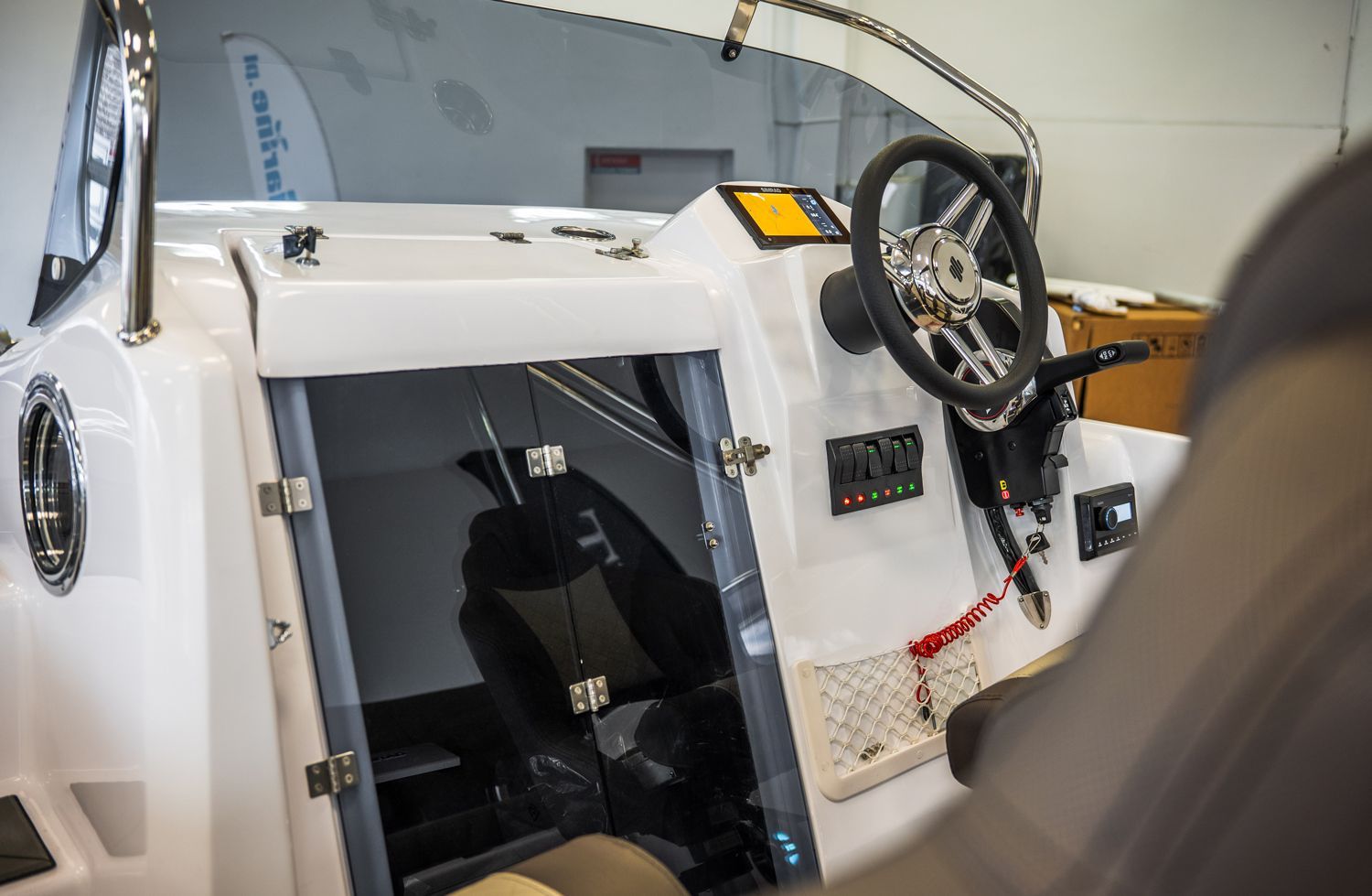 De binnenkant van een boot met een stuurwiel en dashboard