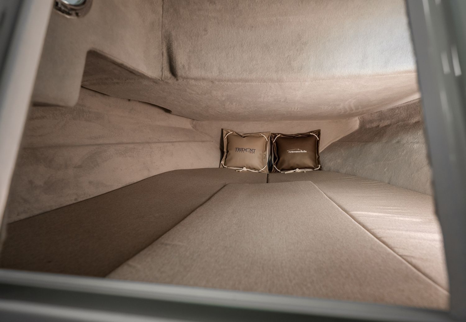 De binnenkant van een boot met een bed en twee kussens.