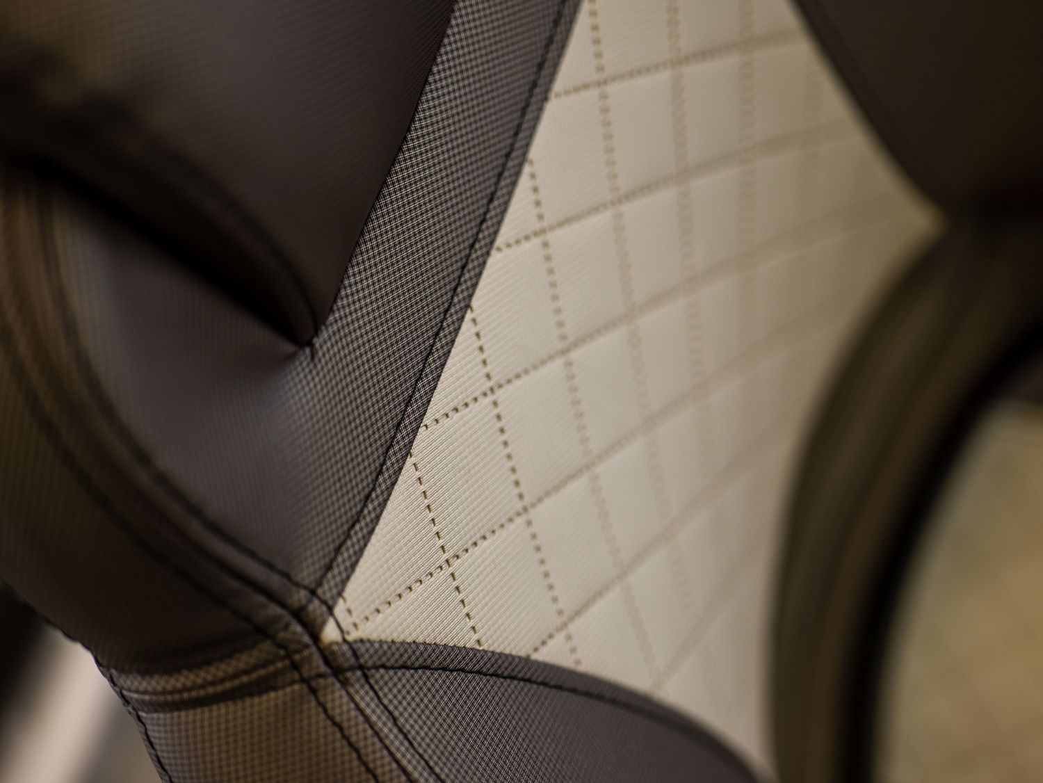 Een close-up van een zwart-witte stoel met een gewatteerd patroon.