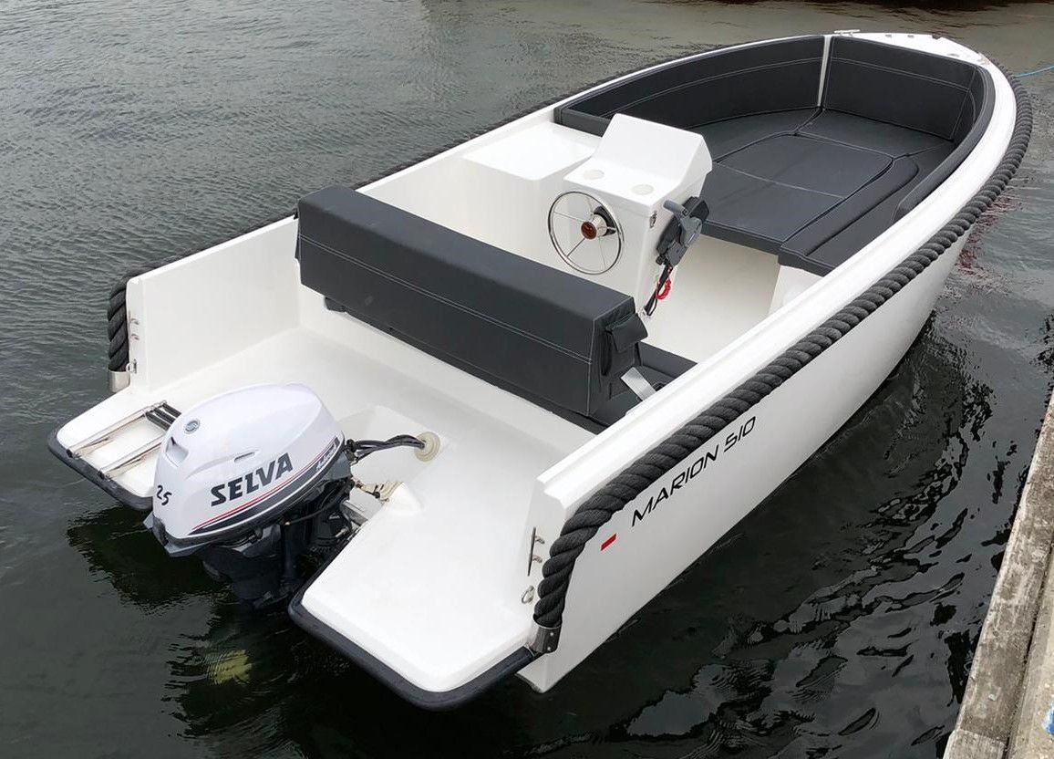 Een kleine witte boot met een zilveren buitenboordmotor