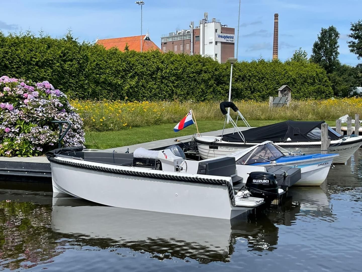 Een paar boten liggen aangemeerd aan een waterpartij.