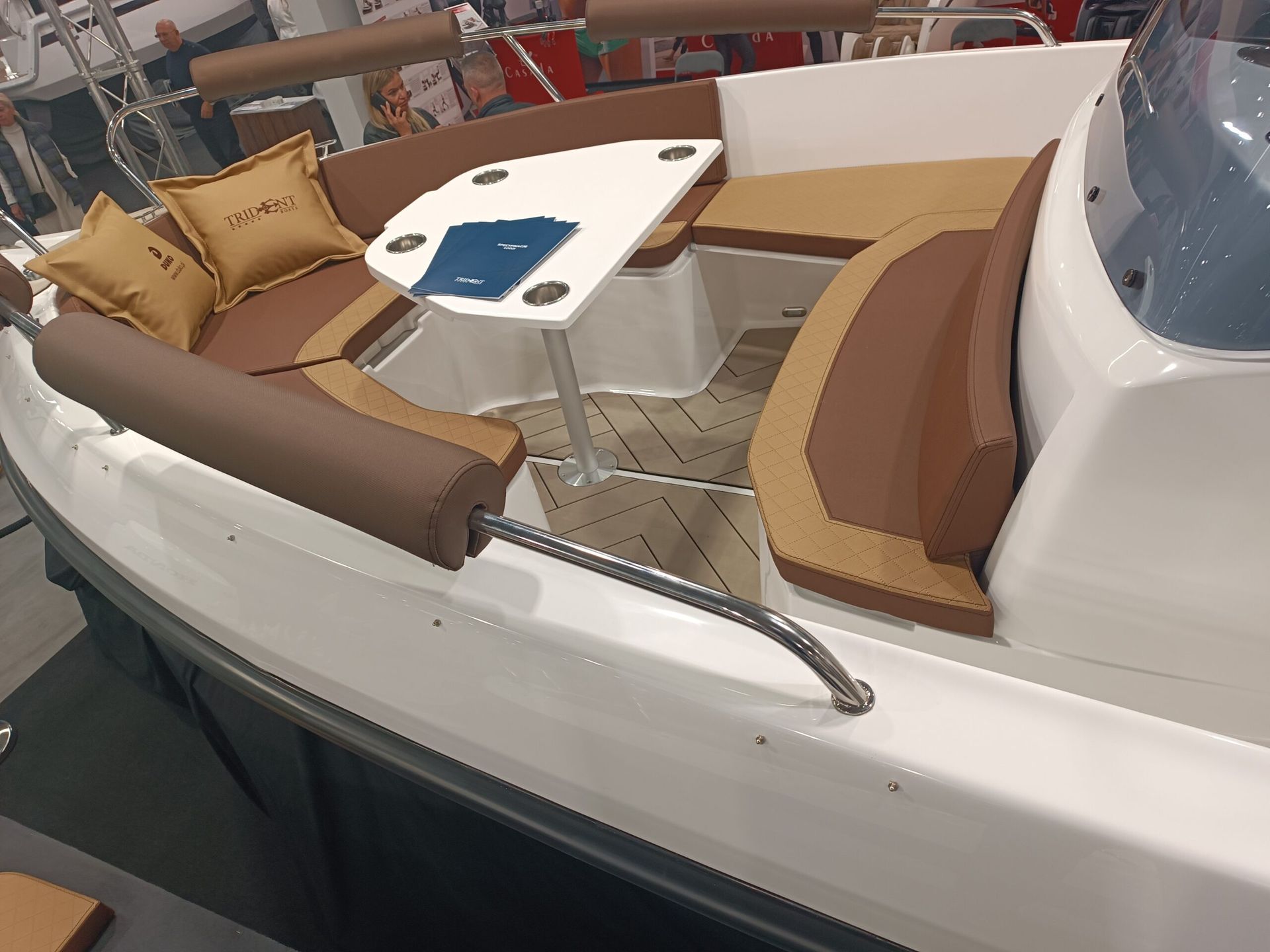 Een witte boot met bruine stoelen en een tafel