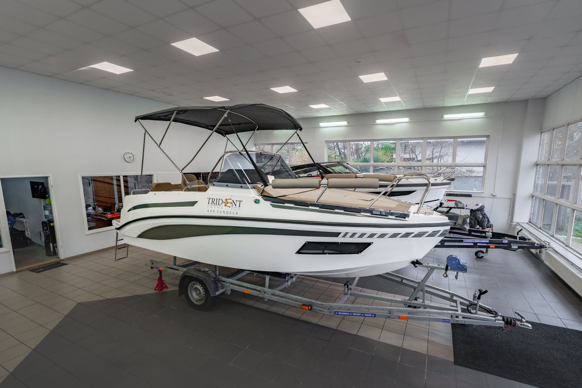 Een boot staat op een trailer in een showroom.