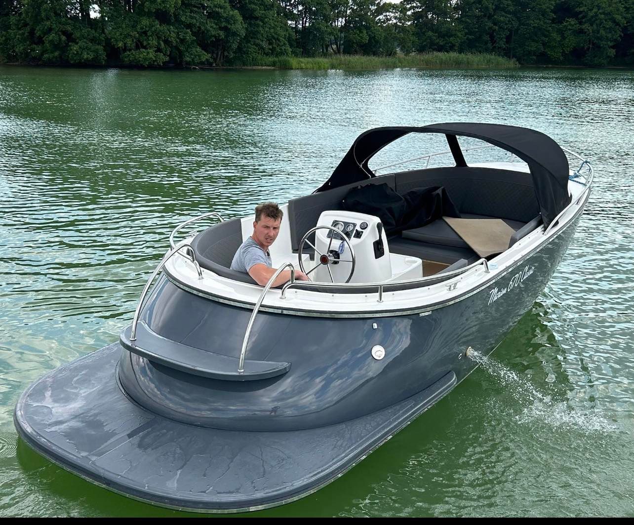 Een man zit in een boot op een meer.