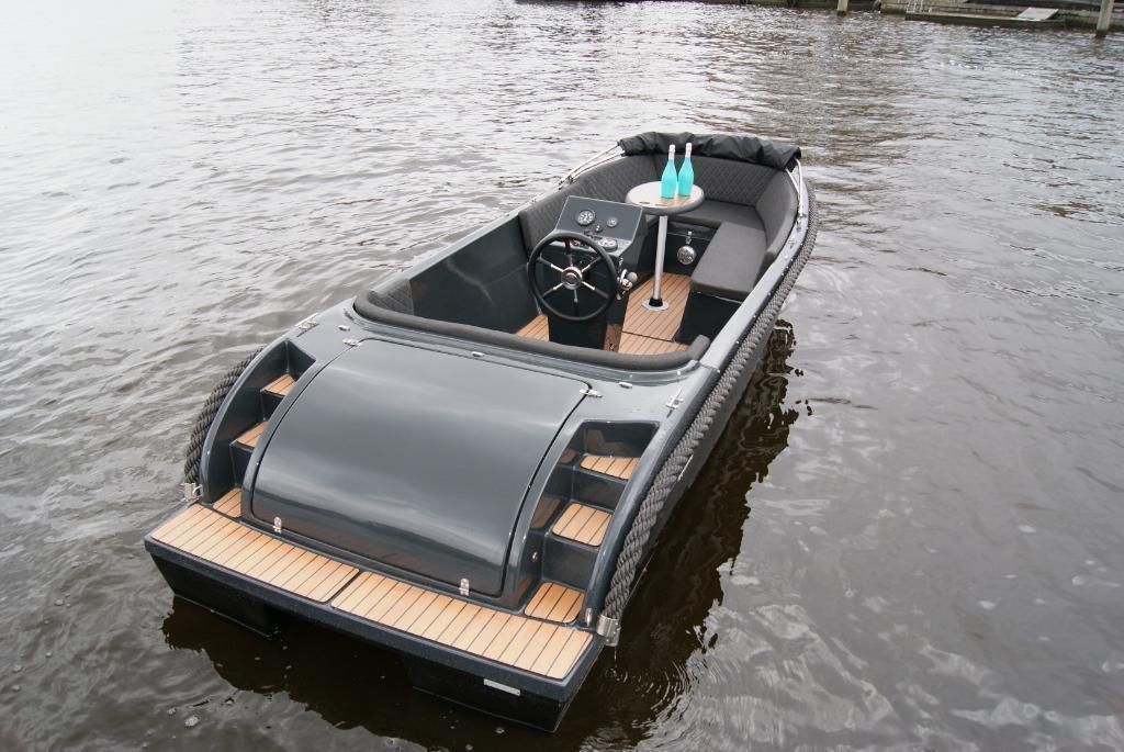 Een zwarte boot drijft op een watermassa.