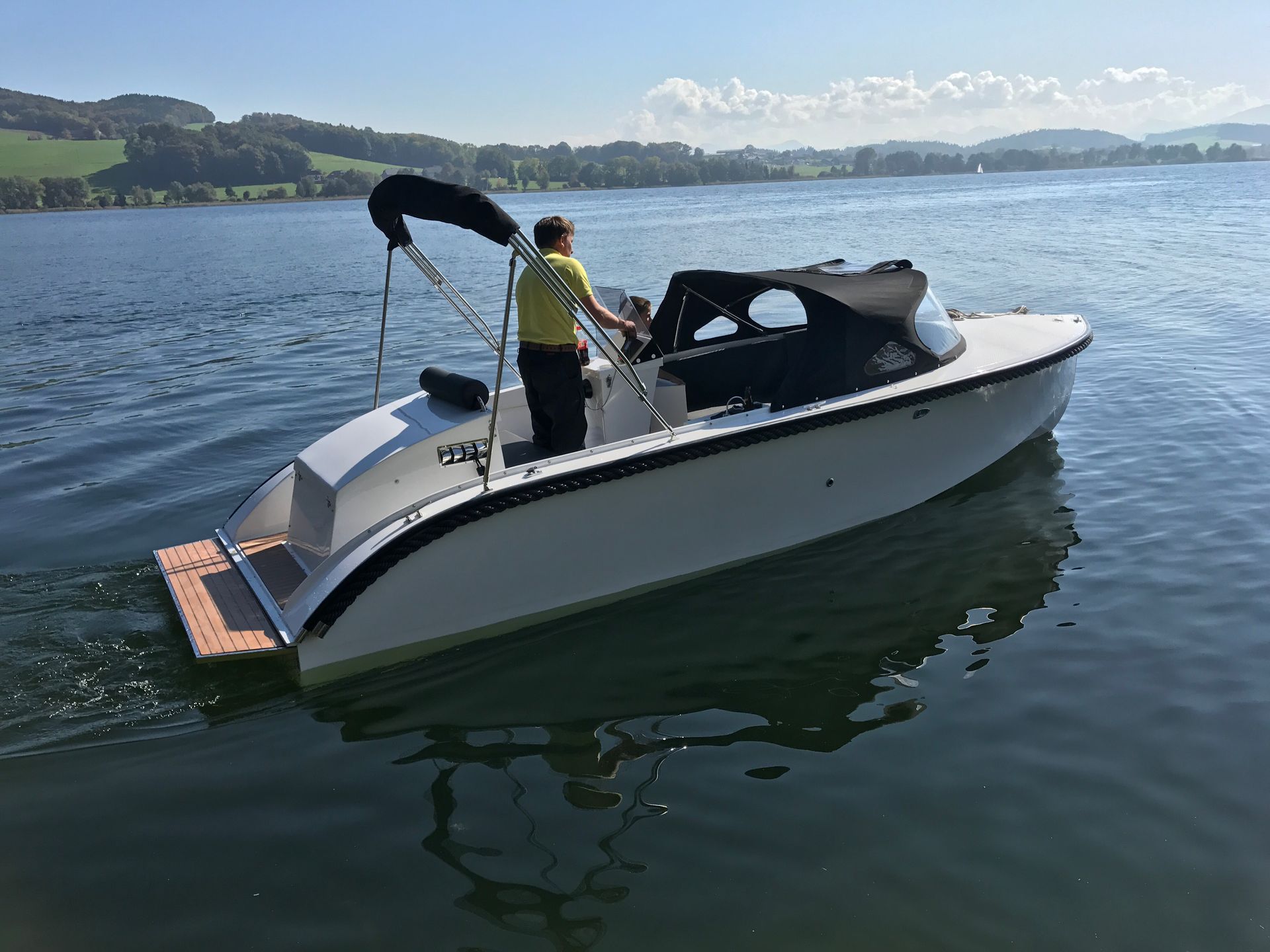 Een man staat op een boot in het water.