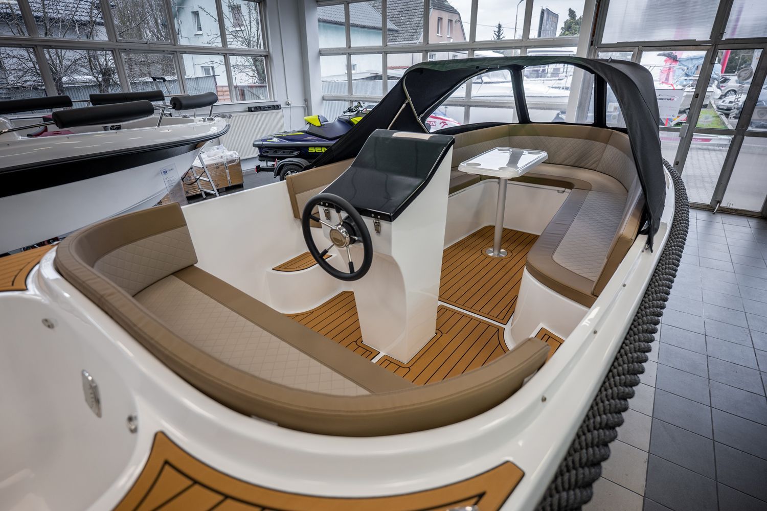 De binnenkant van een boot met een tafel en een stuurwiel.