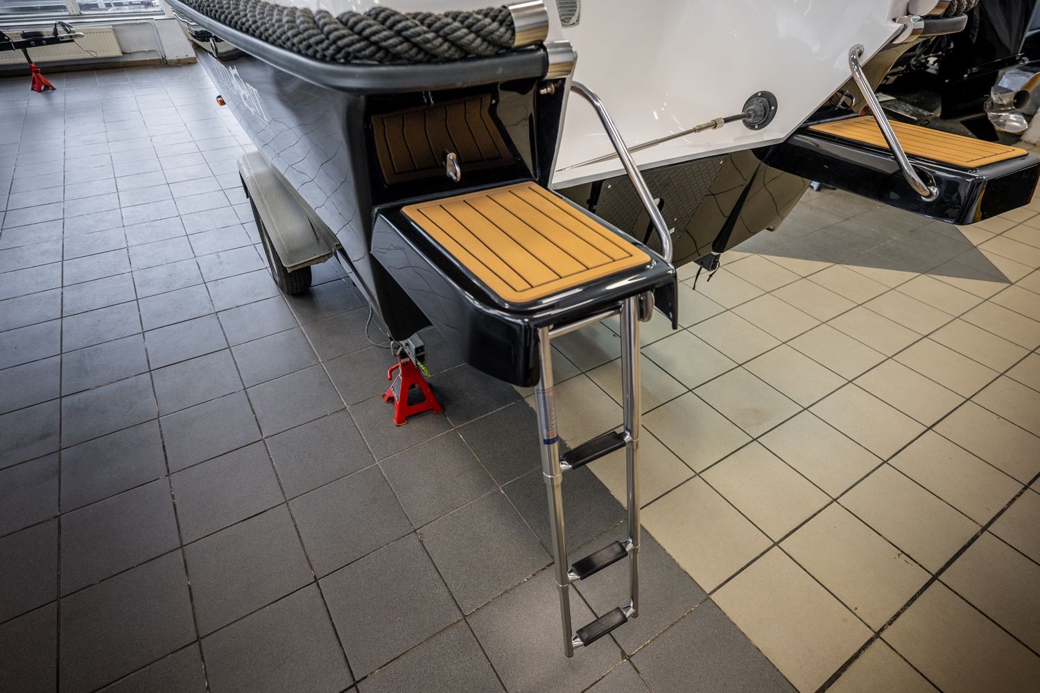 Een boot met aan de achterkant een ladder in een showroom.