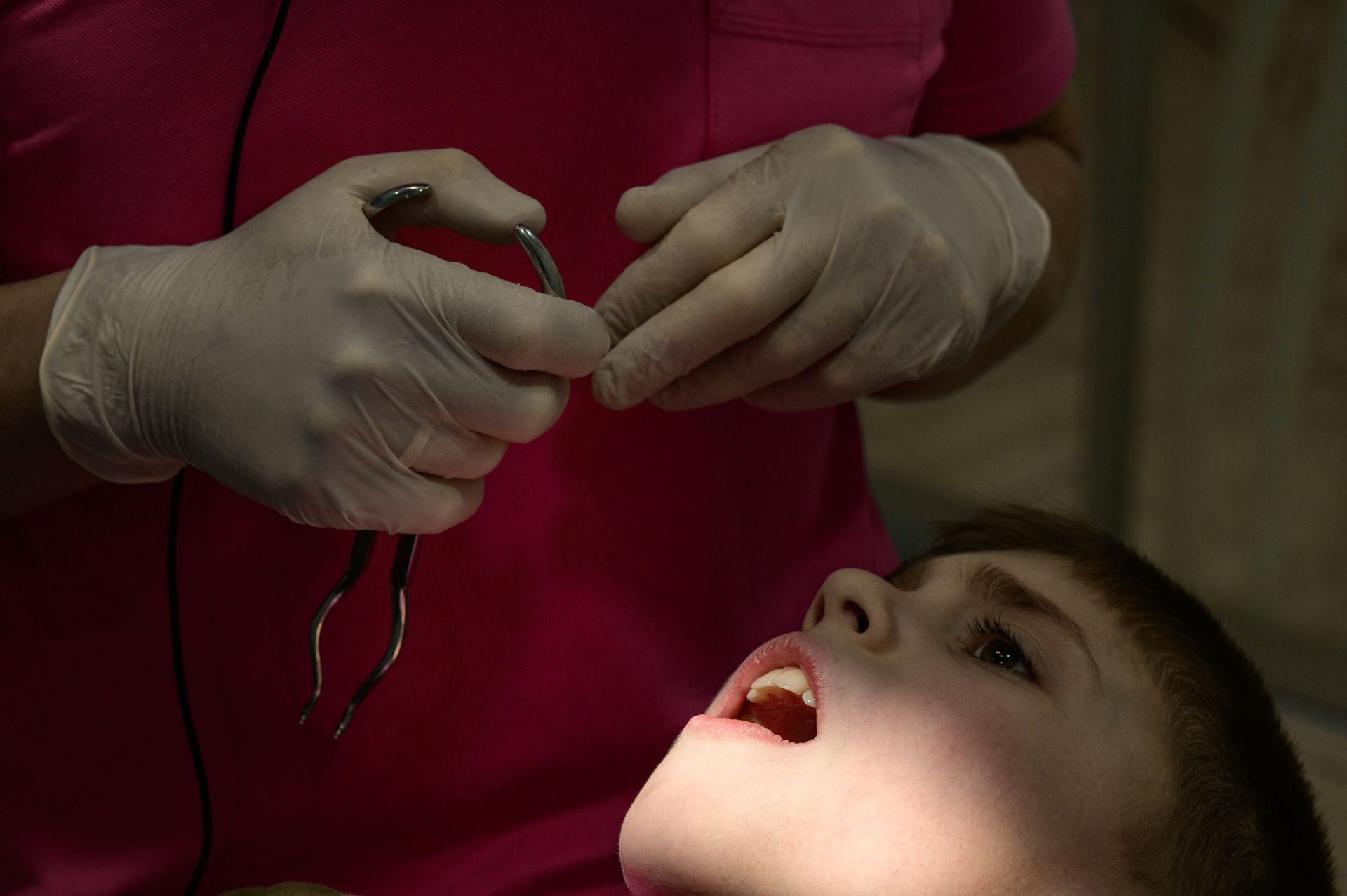 A young boy is getting his teeth examined by a dentist.