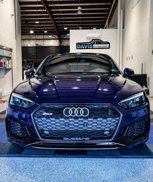 Blue Audi sports car in a garage, front view with hexagonal grille and Audi logo