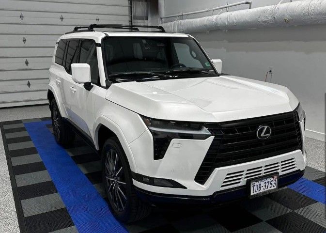 White Lexus SUV parked indoors on a blue-and-black checkered floor