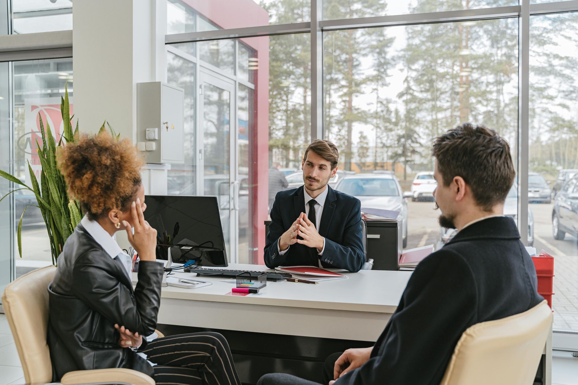 A man and a woman are sitting at a table talking to a salesman.