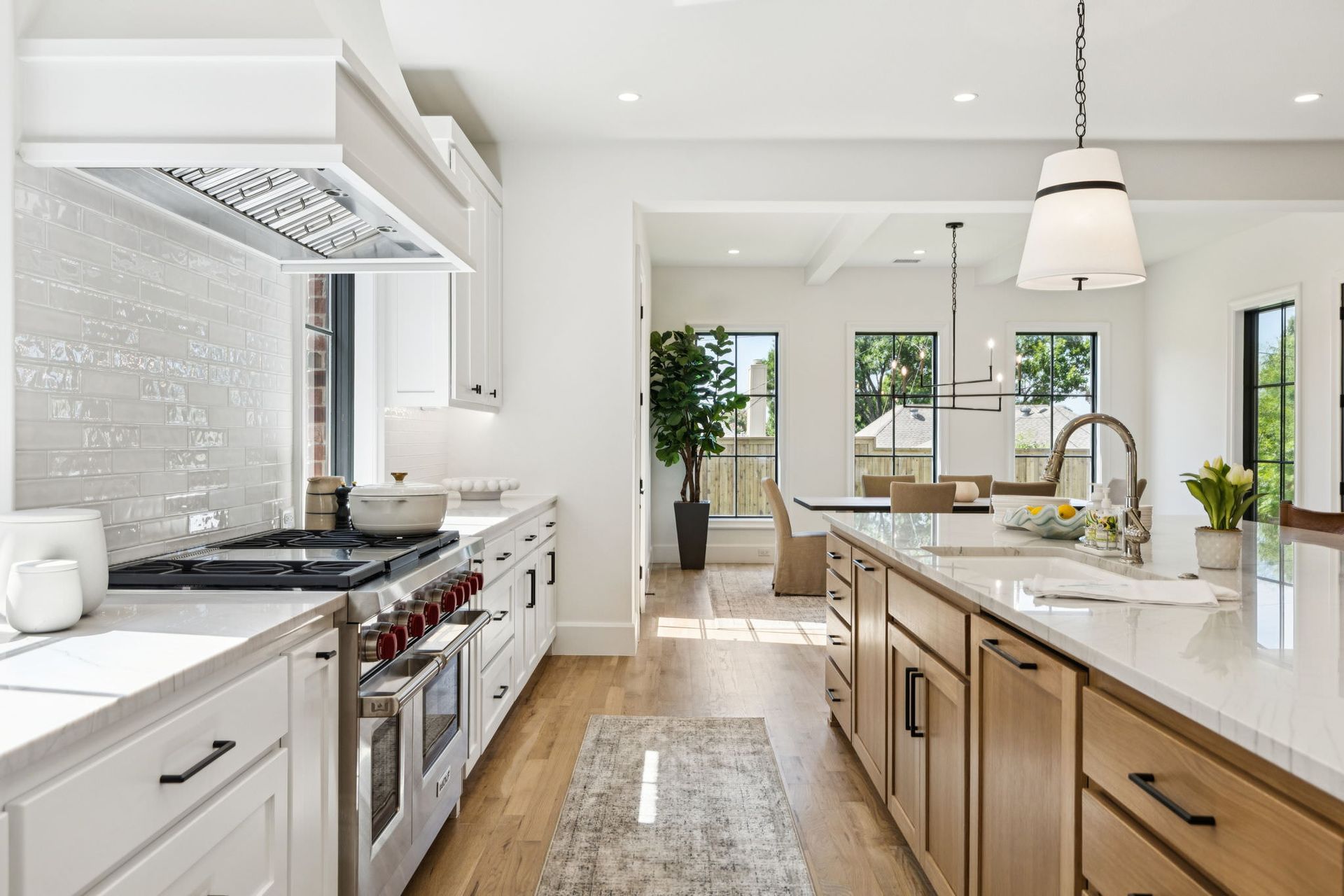 Modern kitchen with white cabinets, stainless steel appliances, and island.