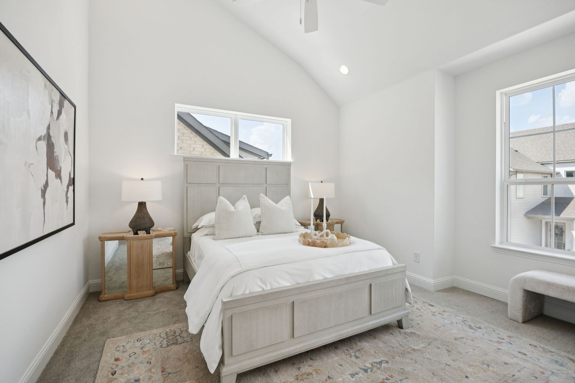Bedroom with a bed, two lamps, a window, and artwork on the wall.