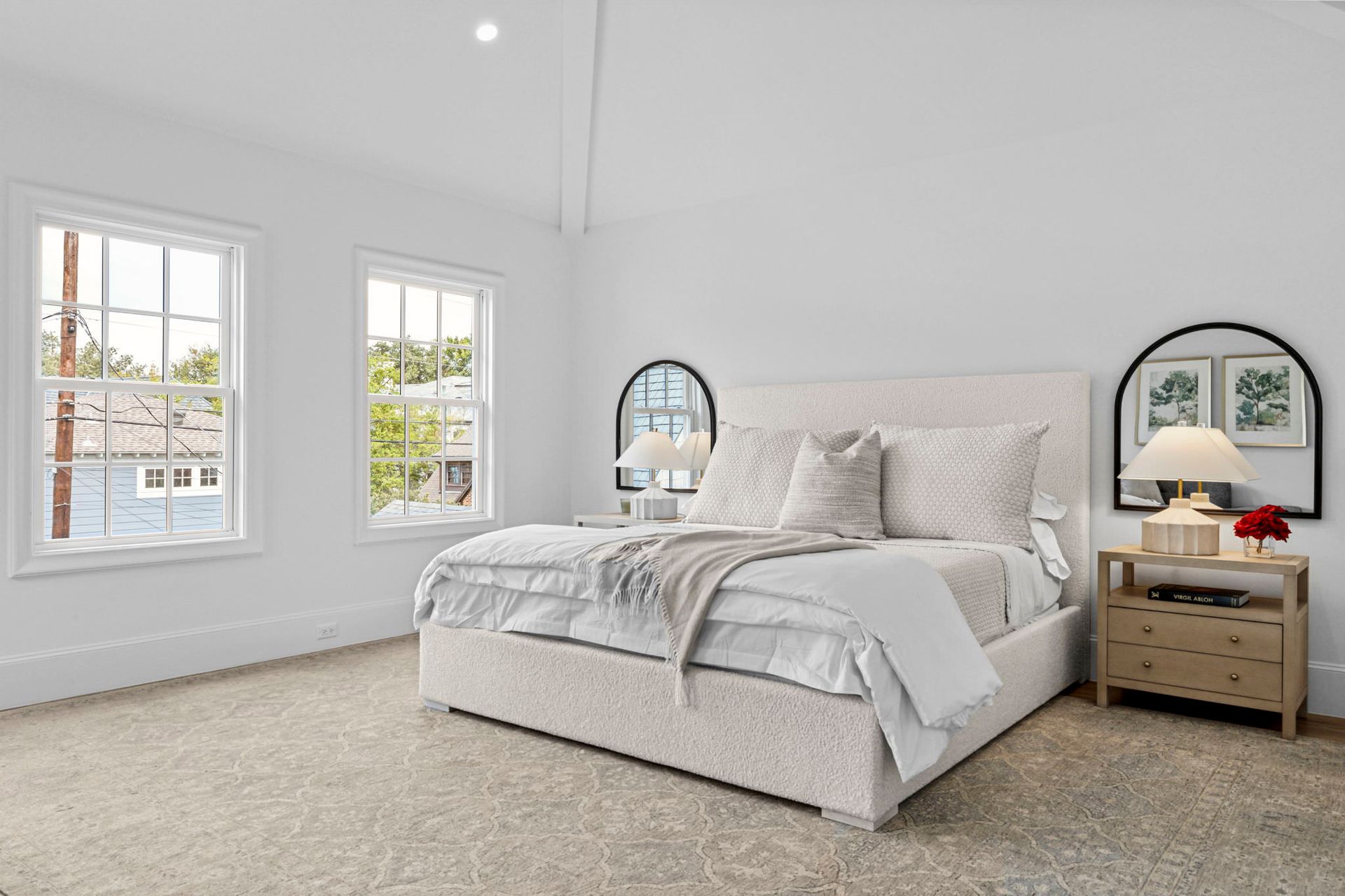 Bedroom with white walls, two windows, large bed with white bedding, and two nightstands.