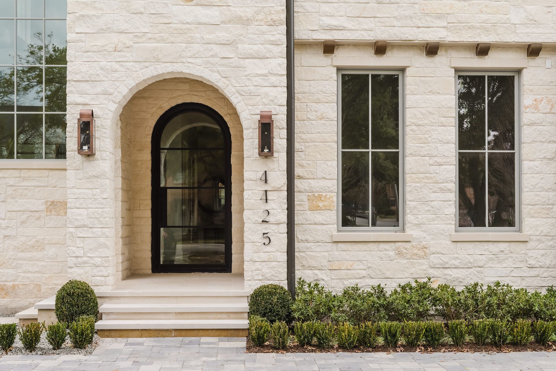 A white brick house with a black door and windows
