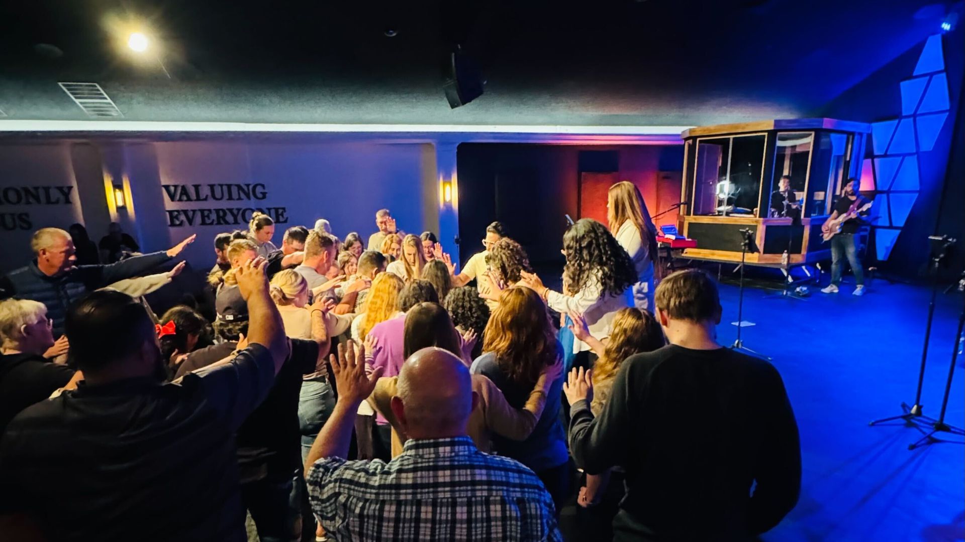 A large group of people are standing in front of a stage.