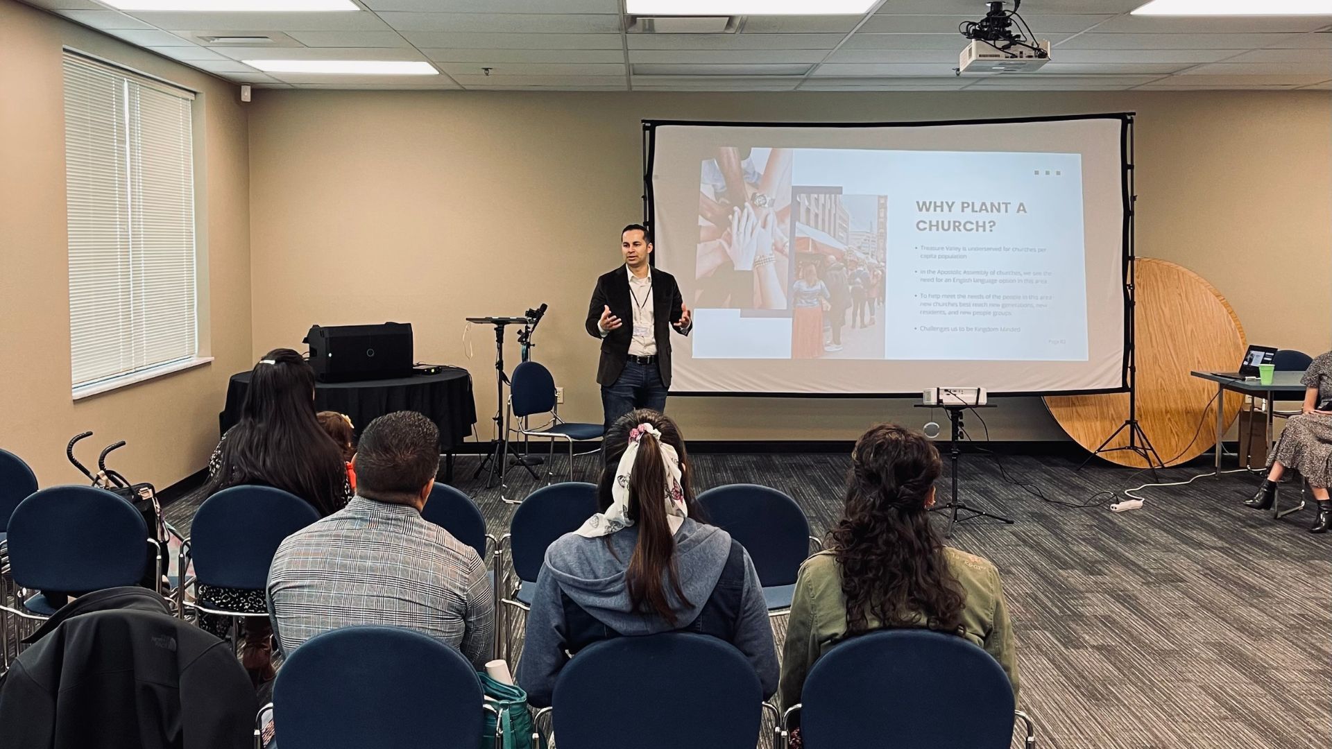 A man is giving a presentation to a group of people in a room.