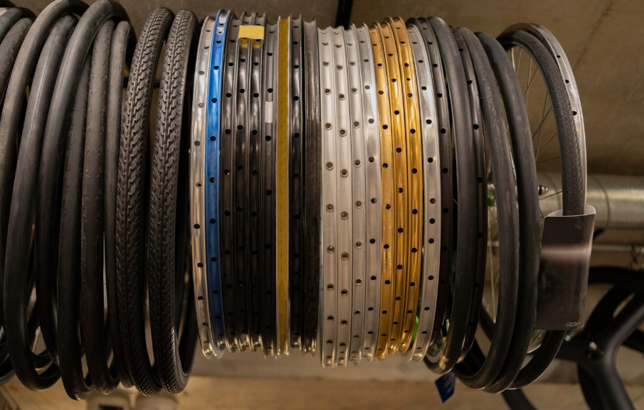 Bobine di filo o cavo arrotolato e impilate su un supporto, con sezioni nere, blu, bianche e gialle.