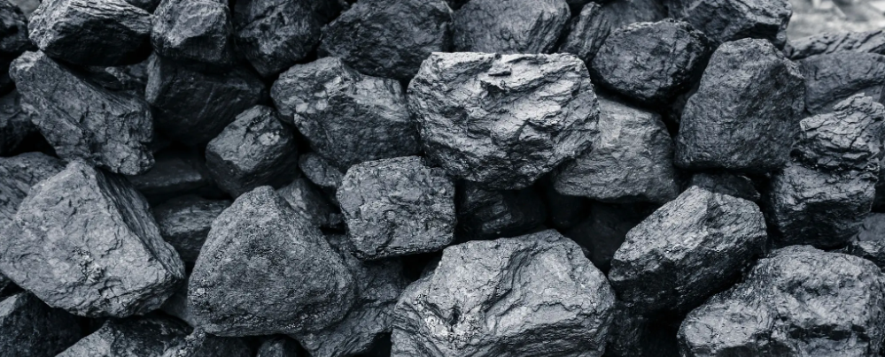 Cumuli di carbone nero con superfici ruvide e irregolari
