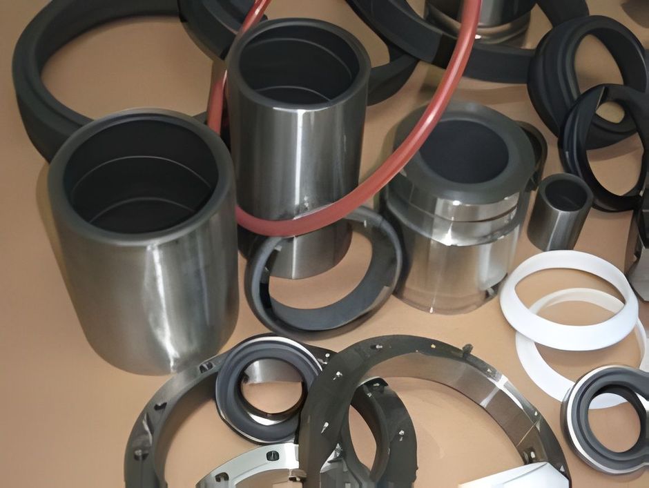 Raccordi, anelli e giunti per tubi in metallo e plastica di vario tipo sparsi su una superficie