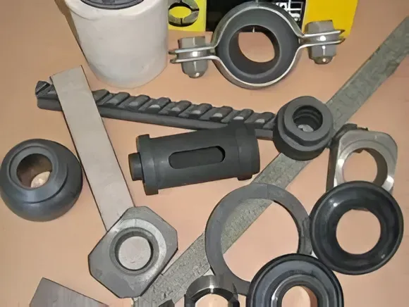 Vari componenti e staffe metalliche nere e grigie sono sparsi su una superficie chiara.