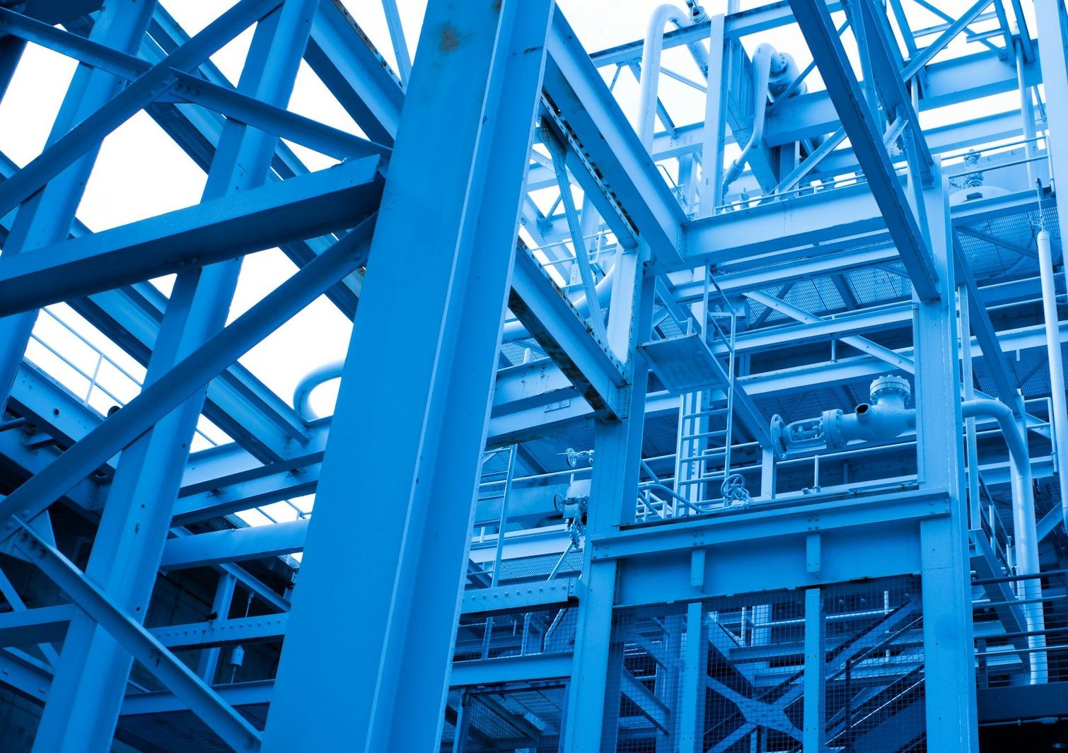 Struttura industriale con telaio in acciaio blu, travi e ponteggi intersecanti, vista dal basso.