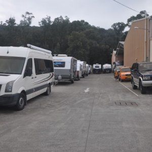 A row of rvs are parked in a parking lot.