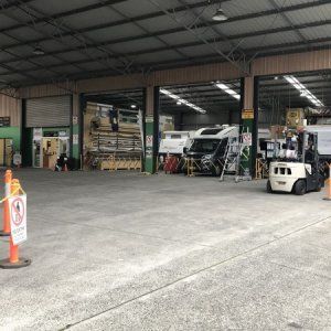 A large warehouse with a forklift parked in the middle of it.