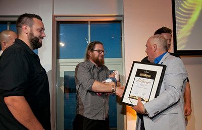 A group of men are standing around a man holding a certificate.