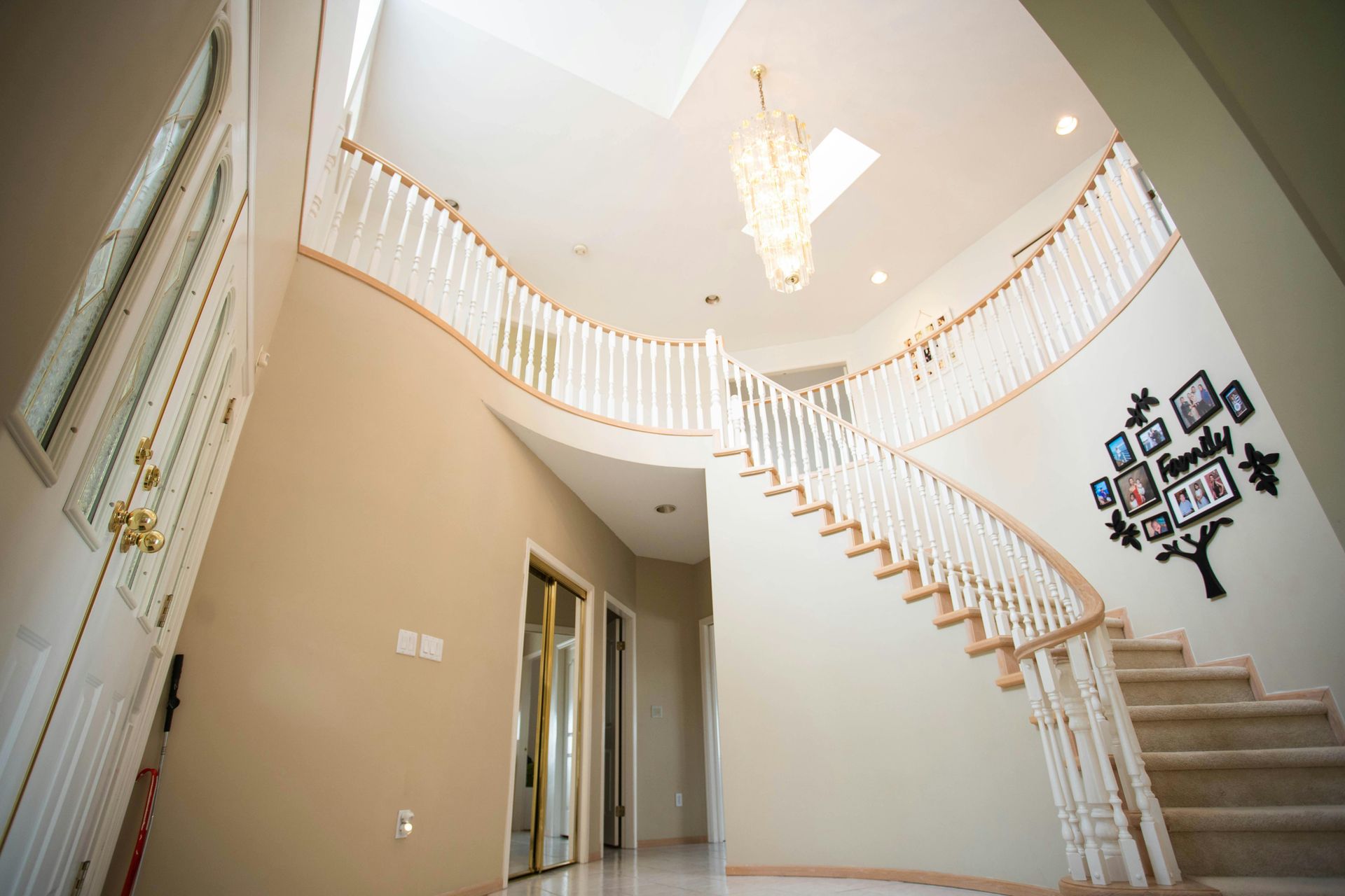 Eine große Treppe in einem Haus mit einem Kronleuchter, der von der Decke hängt.