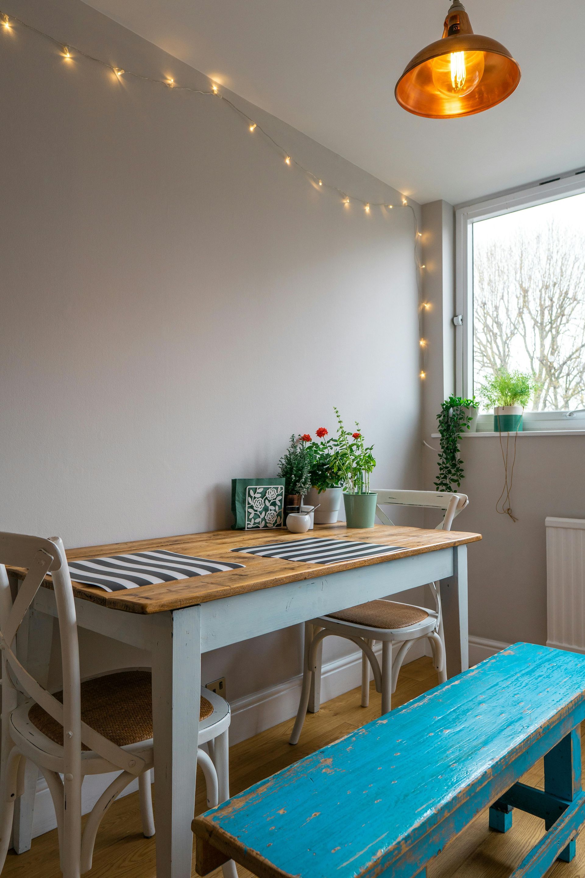 Ein Esszimmer mit einem Tisch und Stühlen und einer blauen Bank.