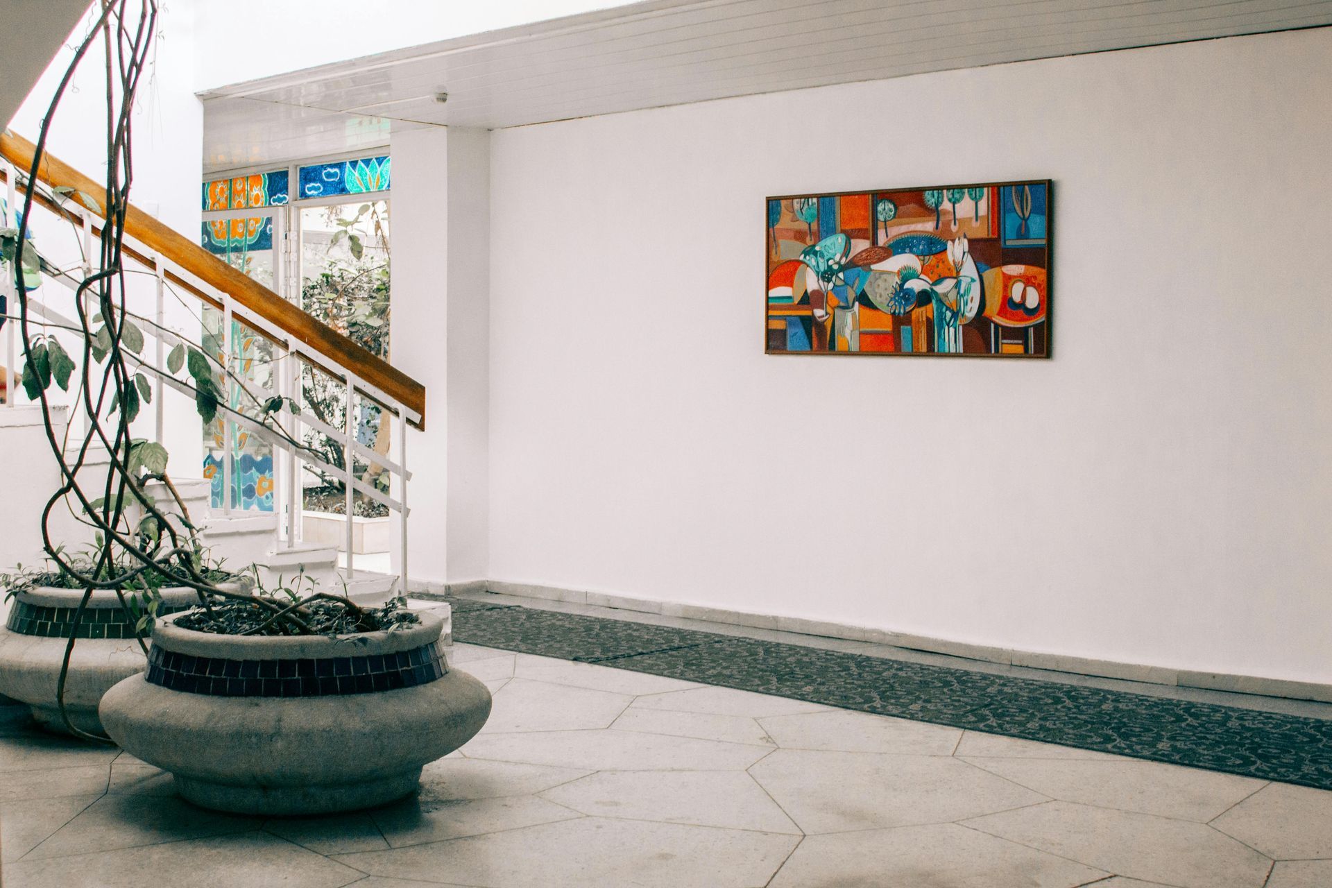 Ein Flur mit Treppe und einem Gemälde an der Wand