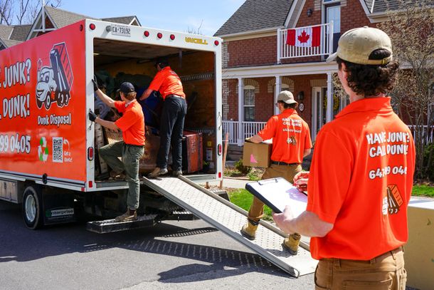 Dunk Disposal crew loading junk removal truck on residential job in GTA