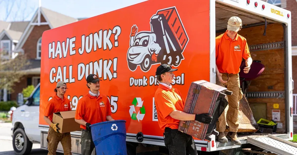 Dunk Disposal junk removal GTA crew loading items onto branded orange truck