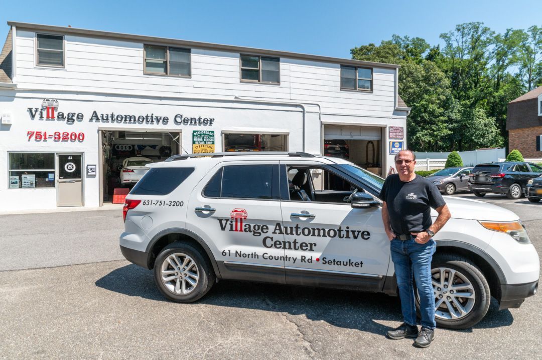 Village Automotive Center, a white SUV, and a building with a garage door.