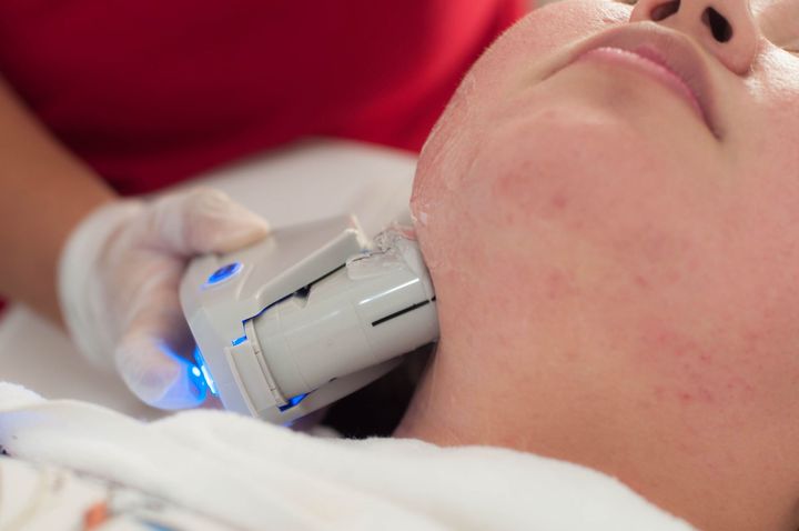 A woman is getting a facial treatment at a beauty salon.