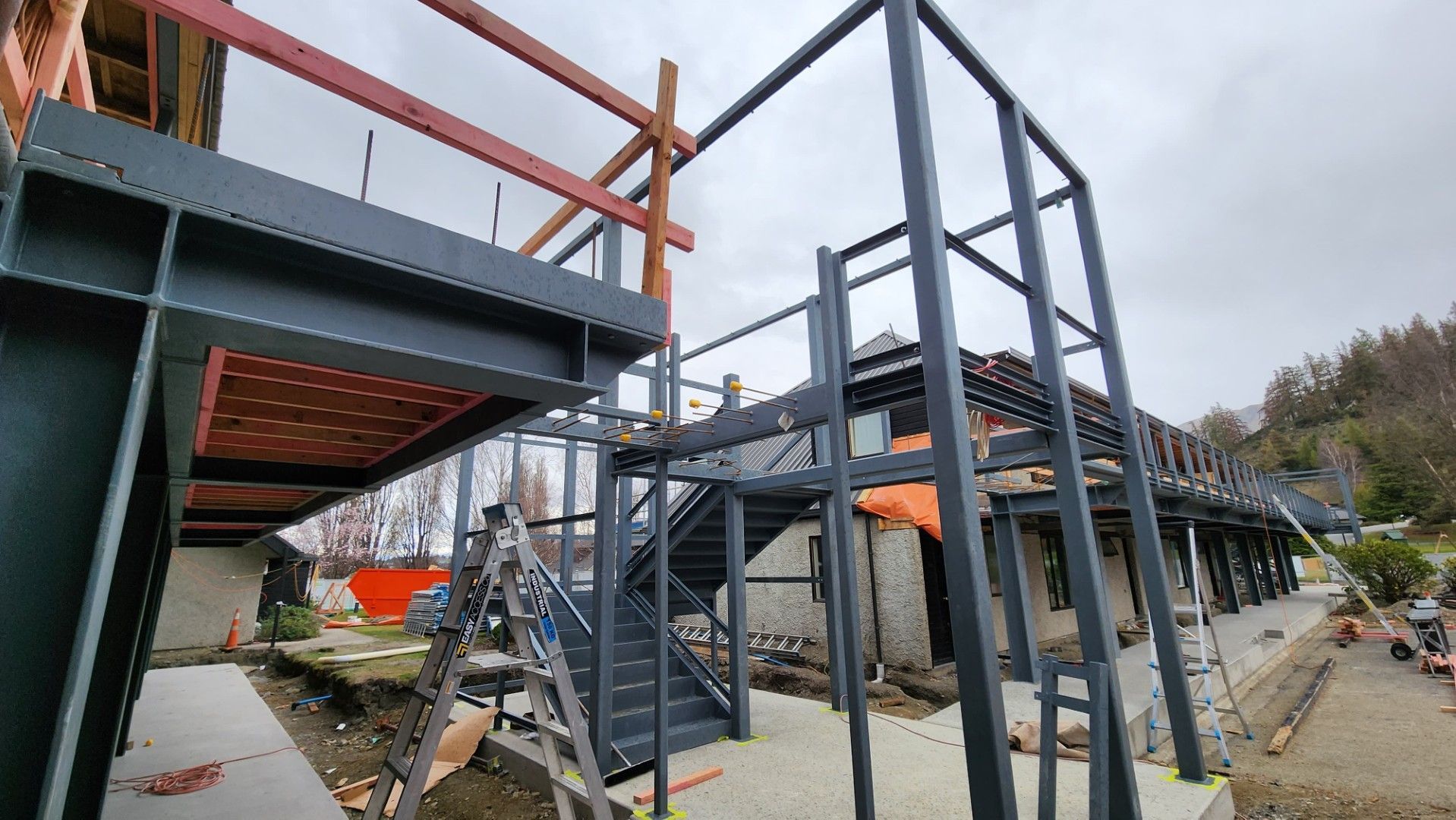 A structural steel building under construction in Christchurch with stairs and a bridge.