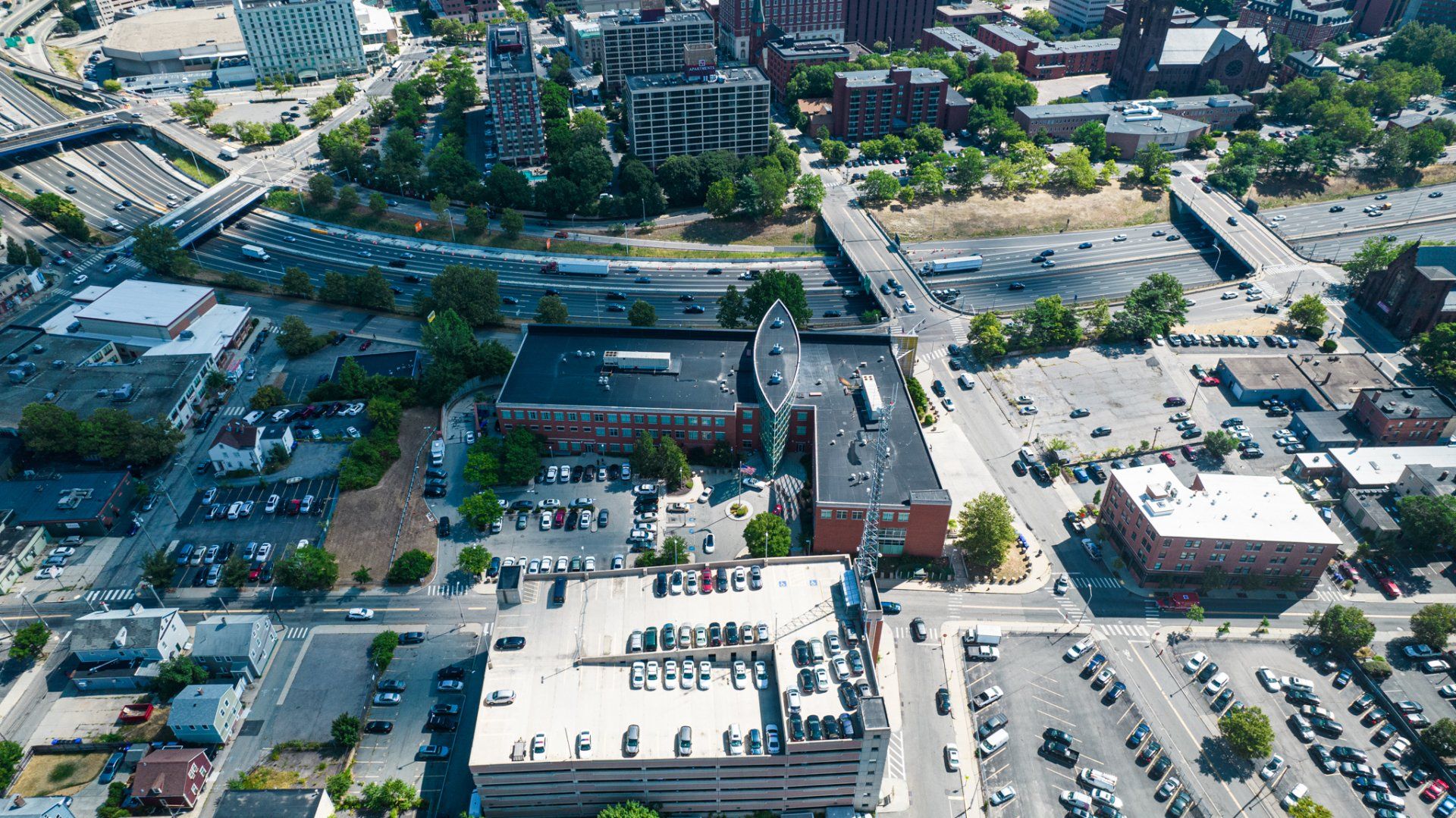 An aerial view of a city with lots of buildings and parking lots.