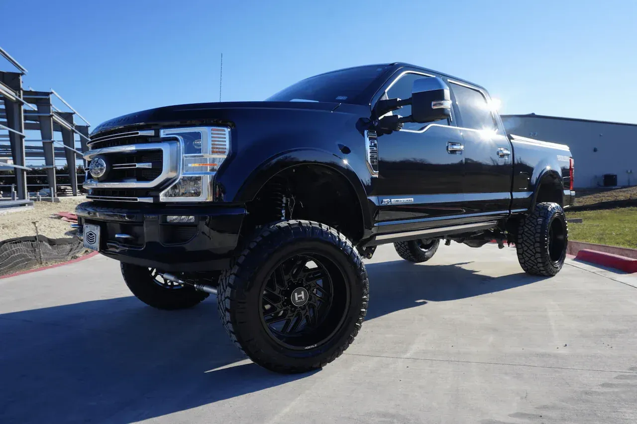 Black lifted pickup truck parked outdoors on a sunny day