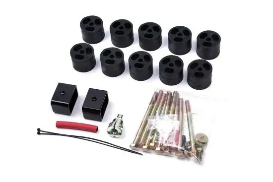 Black suspension lift kit parts laid out on a white background, including spacers, bolts, and brackets